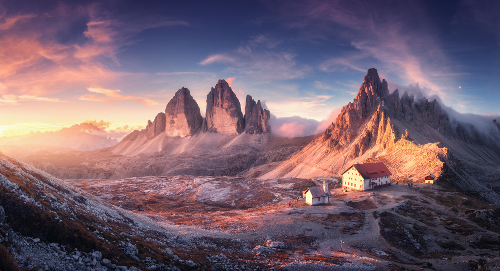 towering snowy mountains with colorful pink clouds in the sky