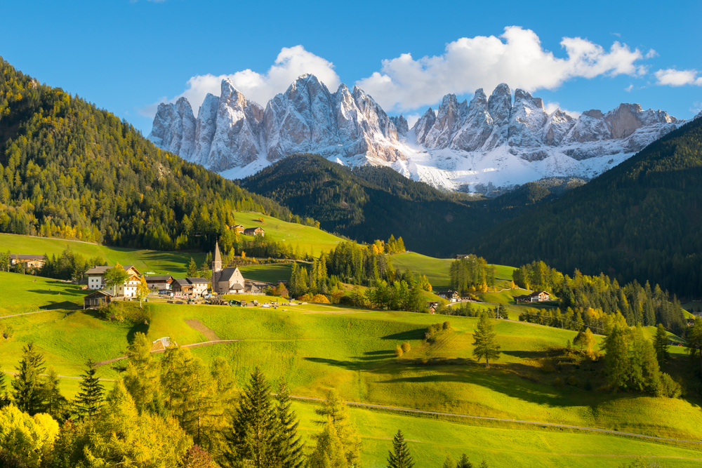 snowy mountains behind bright green valley Northern Italy itinerary