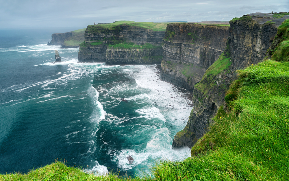 sheer cliffs of Moher with roaring ocean and mist day trips from Dublin