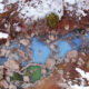 A sky view of two bathers in a milky blue hot springs surrounded by snow covered rocks.
