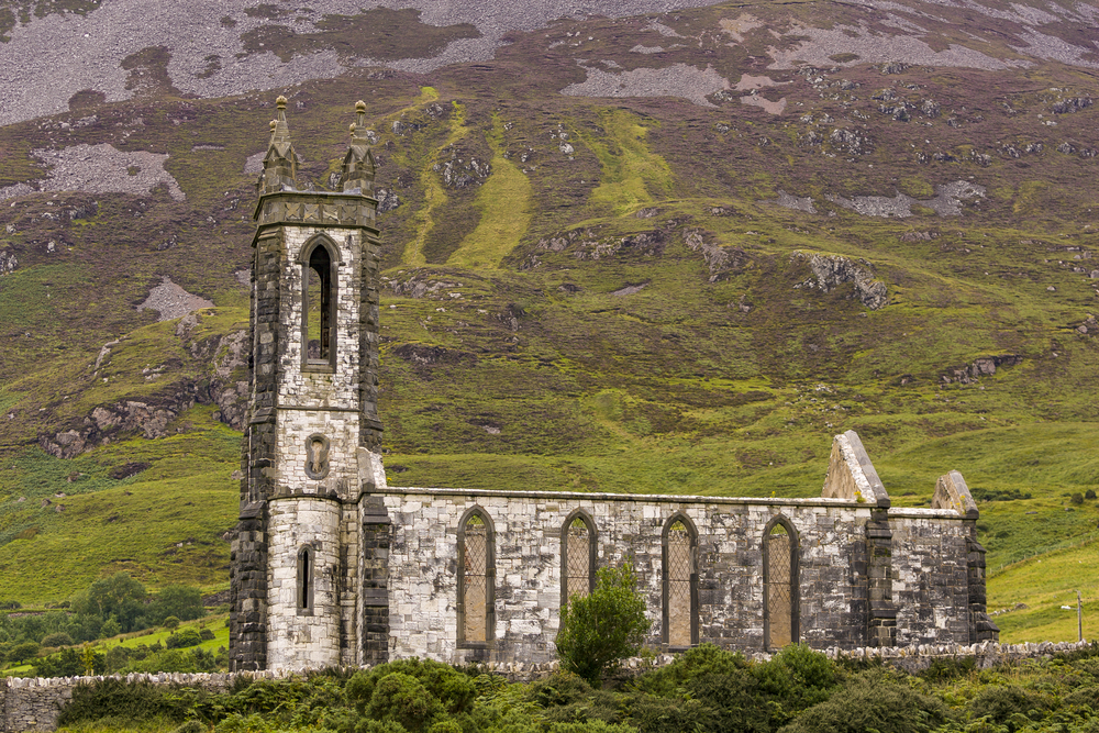 The best things to do in Donegal includes seeing Dunlewey Church ruins in Poisoned Glen beneath a mountain.