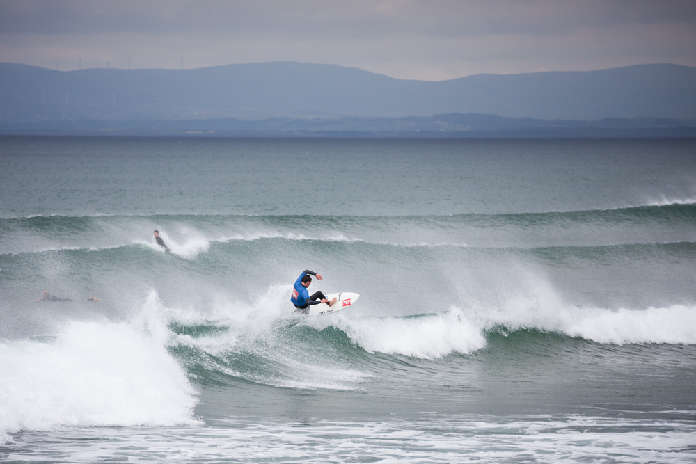 A surfer catches a wave in the cold waters off the coast of Donegal.