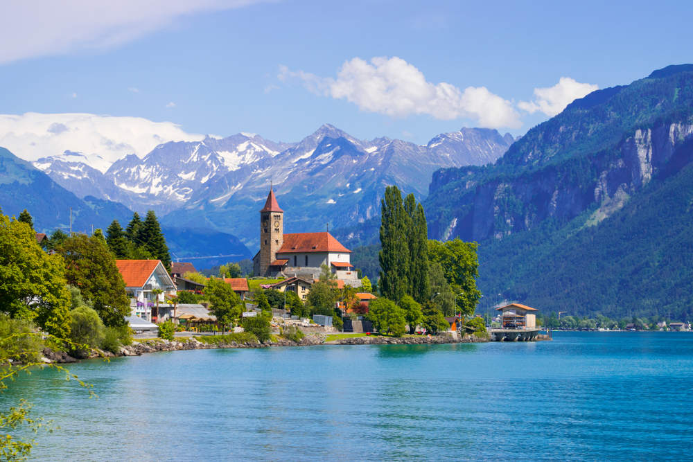 Interlaken a small Swiss town with the lake in the foreground and mountains in the background. 