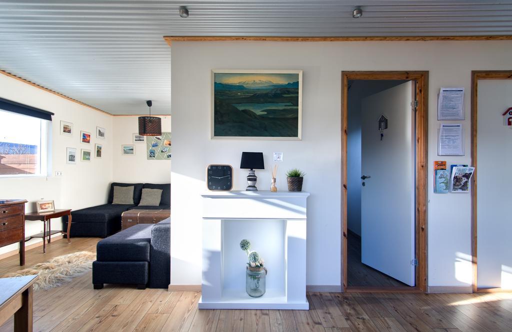 Photo of the interior of Blue House B&B located in Vik Iceland. A cozy nook seating area is seen on the left with two guest room doors on the right. 