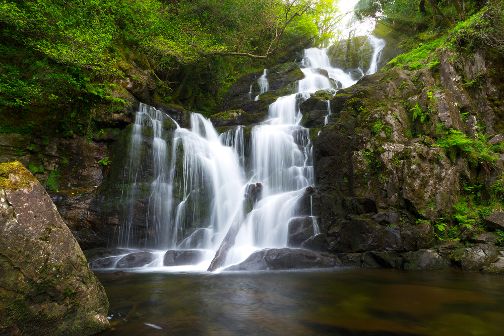 White water cascading down the mountain at Torc Waterfall, a beautiful place in Ireland to visit.