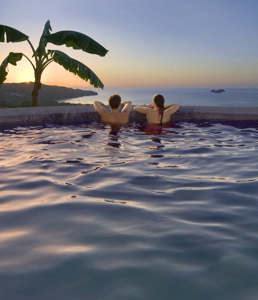 couple enjoying the pool at their resort on their costa rica honeymoon