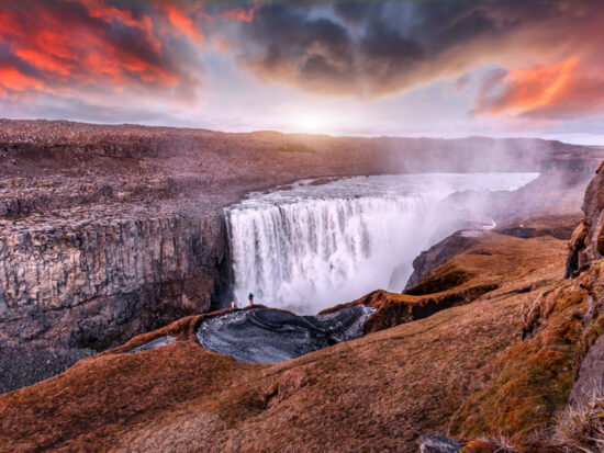 photo of the iconic Dettifoss waterfall, one of the most powerful waterfalls in the world. There is a dramatic sunset sky in the background
