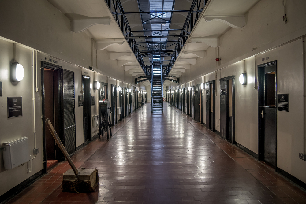 Photo of the inside of Crumlin Road Gaol, one of the most popular things to do in northern ireland. The photo shows a long white hallway with jail cells on both sides.