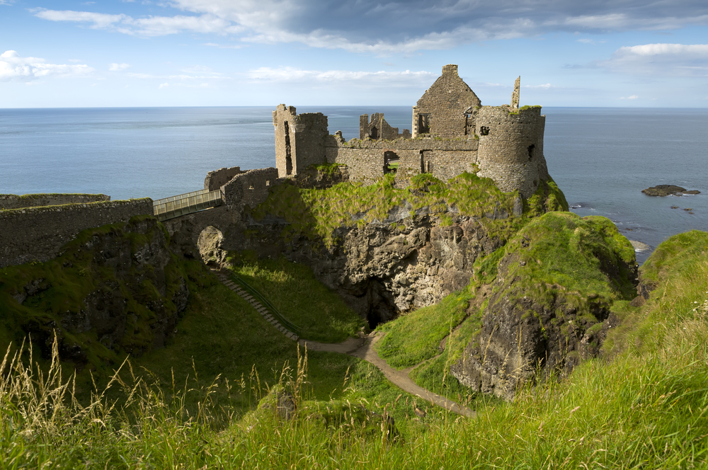 Photo of the ruins of Dunluce Castle. It's situated on a cliff with the sea in the background, one of the many things to do in Northern Ireland.