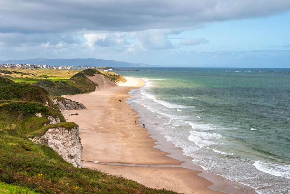 Aerial view of Portrush White Rocks Beach in Northern Ireland. There are limestone cliffs and sand.