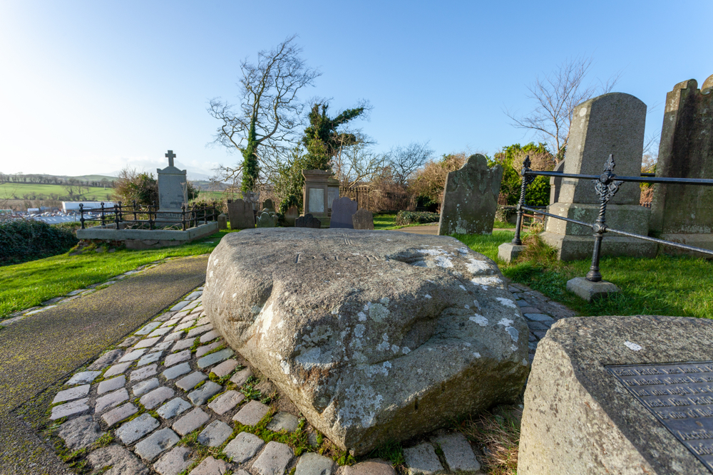 Visting St. Patrick's Grave is one of the things to do in Northern Ireland that tourists take part in. The grave is situated in a churchyard with a massive stone covering it for protection.
