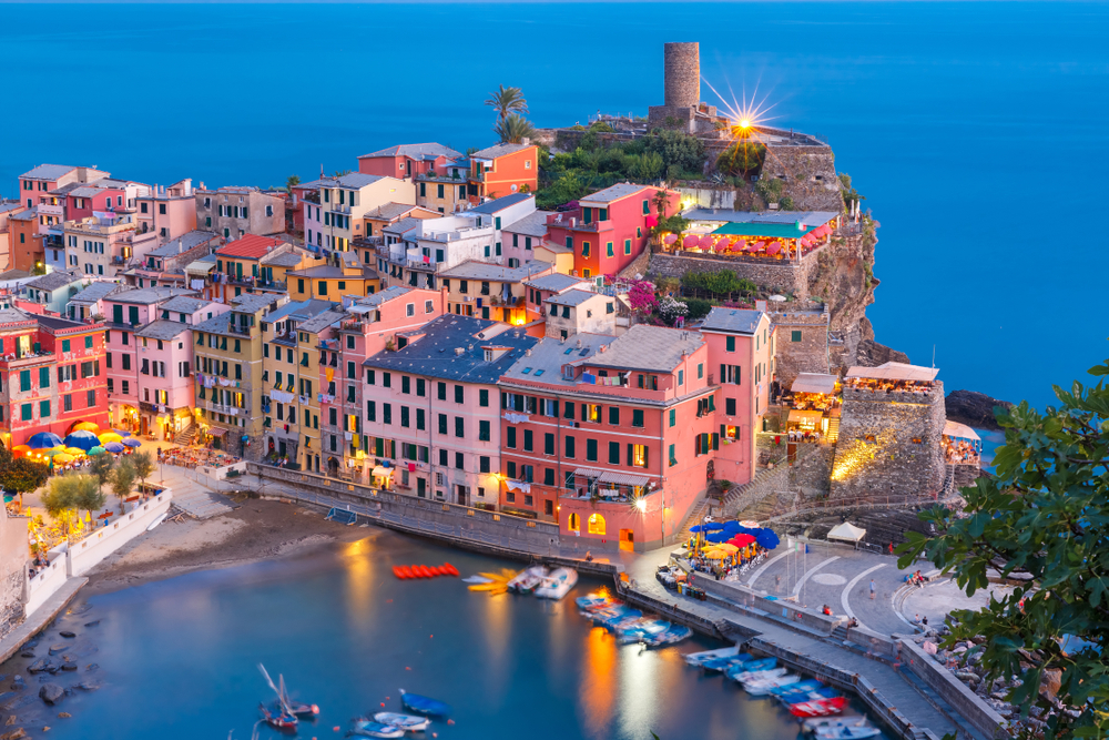 Aerial shot of Vernazza and Doria Tower. It is at night and the lights are on. It is one of the things to do in Cinque Terre.