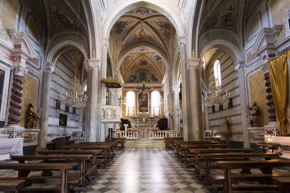 The inside of the Church of Saint Peter showing the seat and the ornate walls and ceiling. One of the things to do in Cinque Terre.