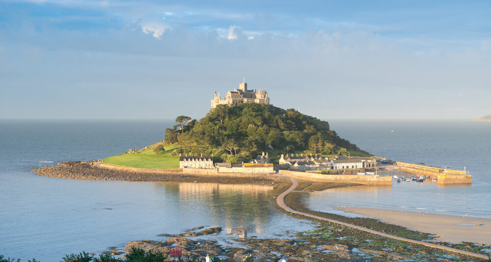 a photo showing St Michael's Mount, a small island with a walkway leading up to it