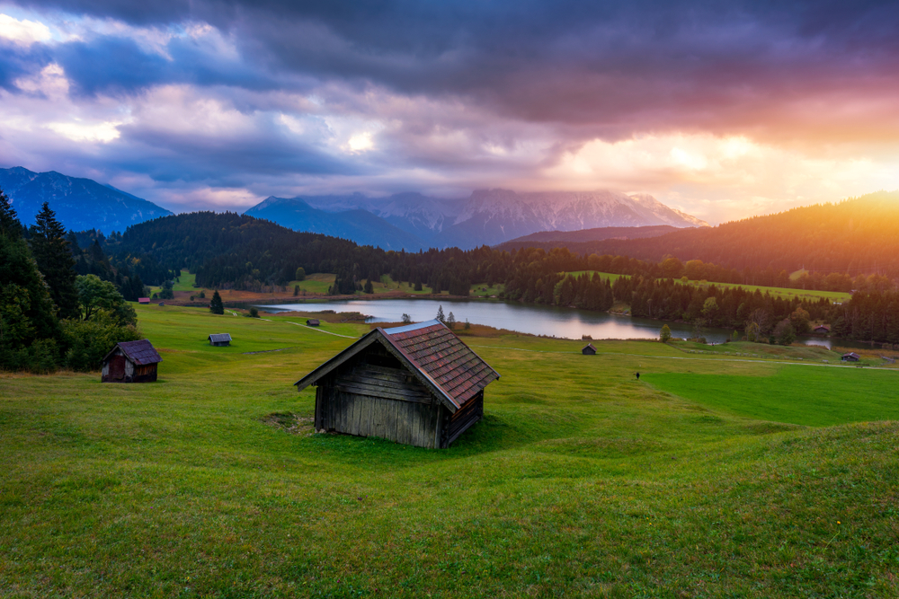 The sun sets behind the mountains in the picturesque valley of Geroldsee