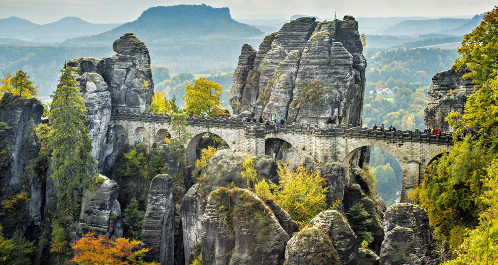 Bastei Bridge seems to float among the rock spires high above the trees.