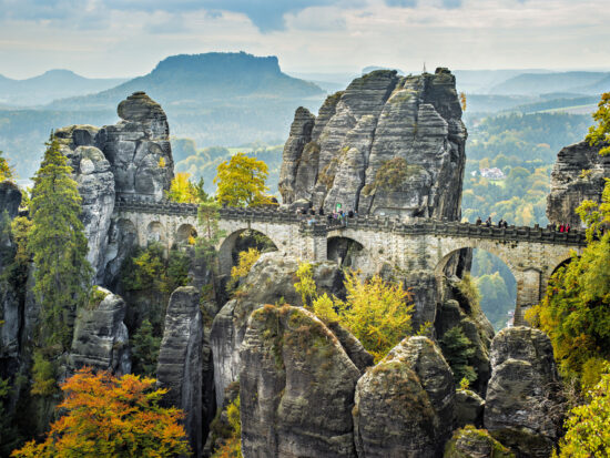 Bastei Bridge seems to float among the rock spires high above the trees.