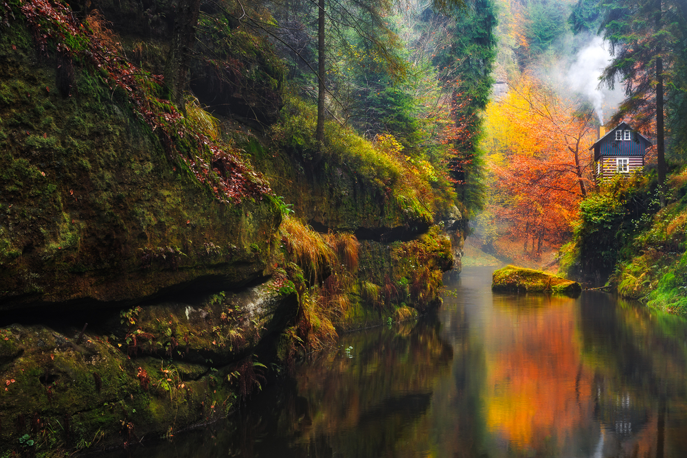 A cabin sits among the autumn foliage at the edge of Kamnitz Gorge, one of the lesser known hidden gems in Germany.