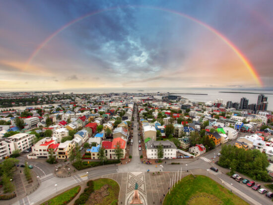 An overhead shot of Reykjavik Iceland with a rainbow backdrop.