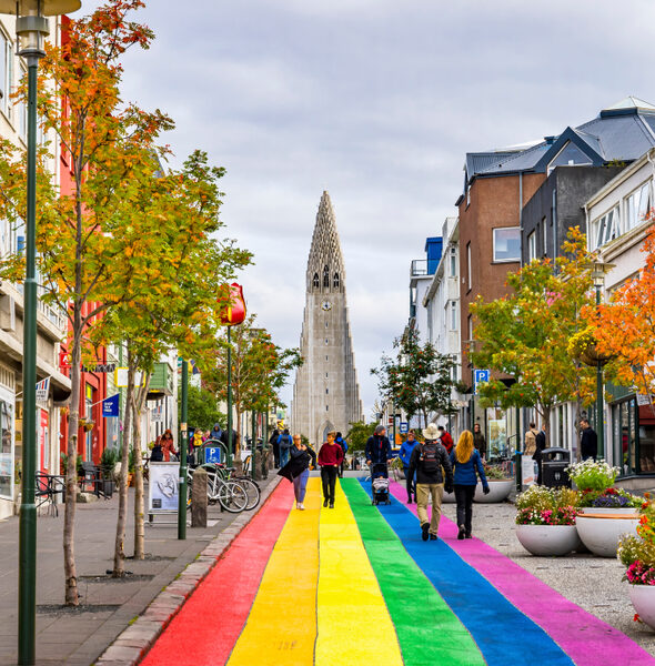 People walk the rainbow painted road in Reykjavik Iceland