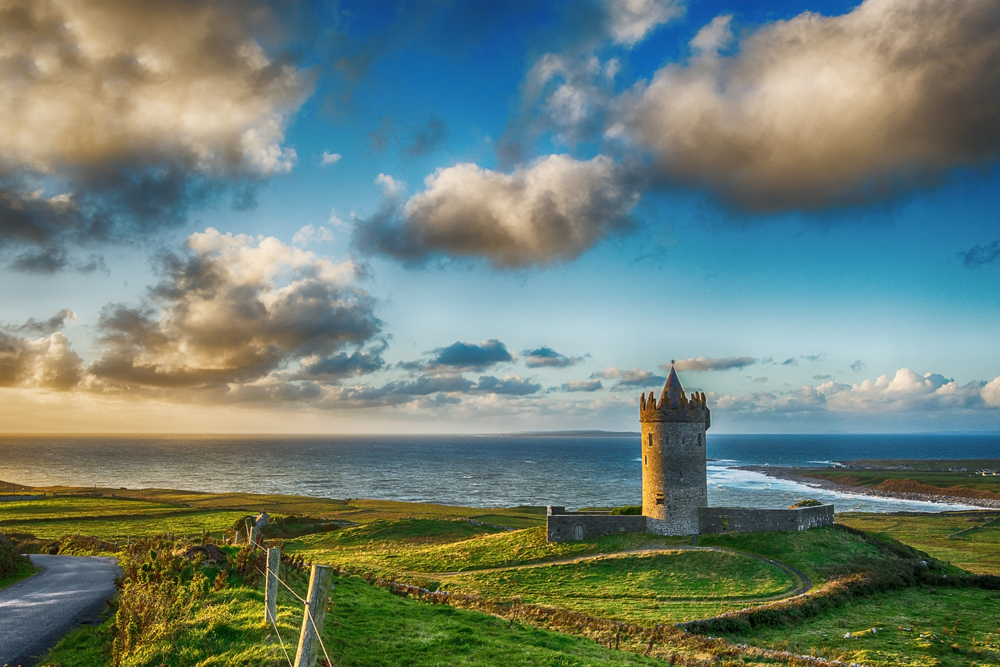 Small castle tower in green field overlooking the ocean in Doolin.