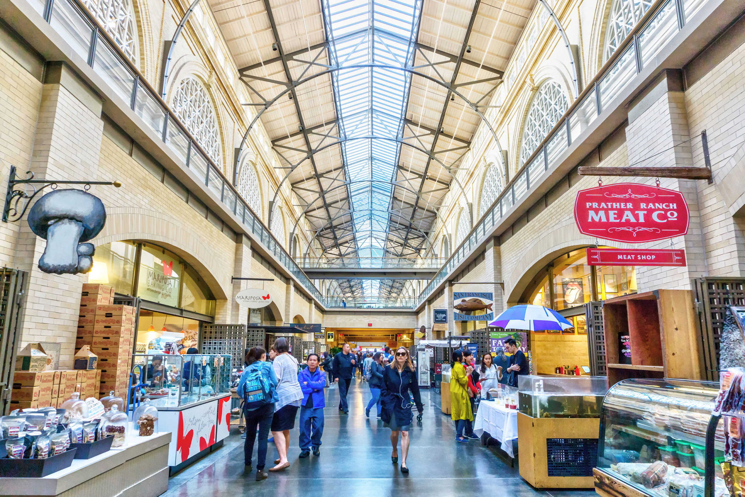 Photo of the inside of the Ferry Building in San Francisco featuring multiple vendors and tourists. 