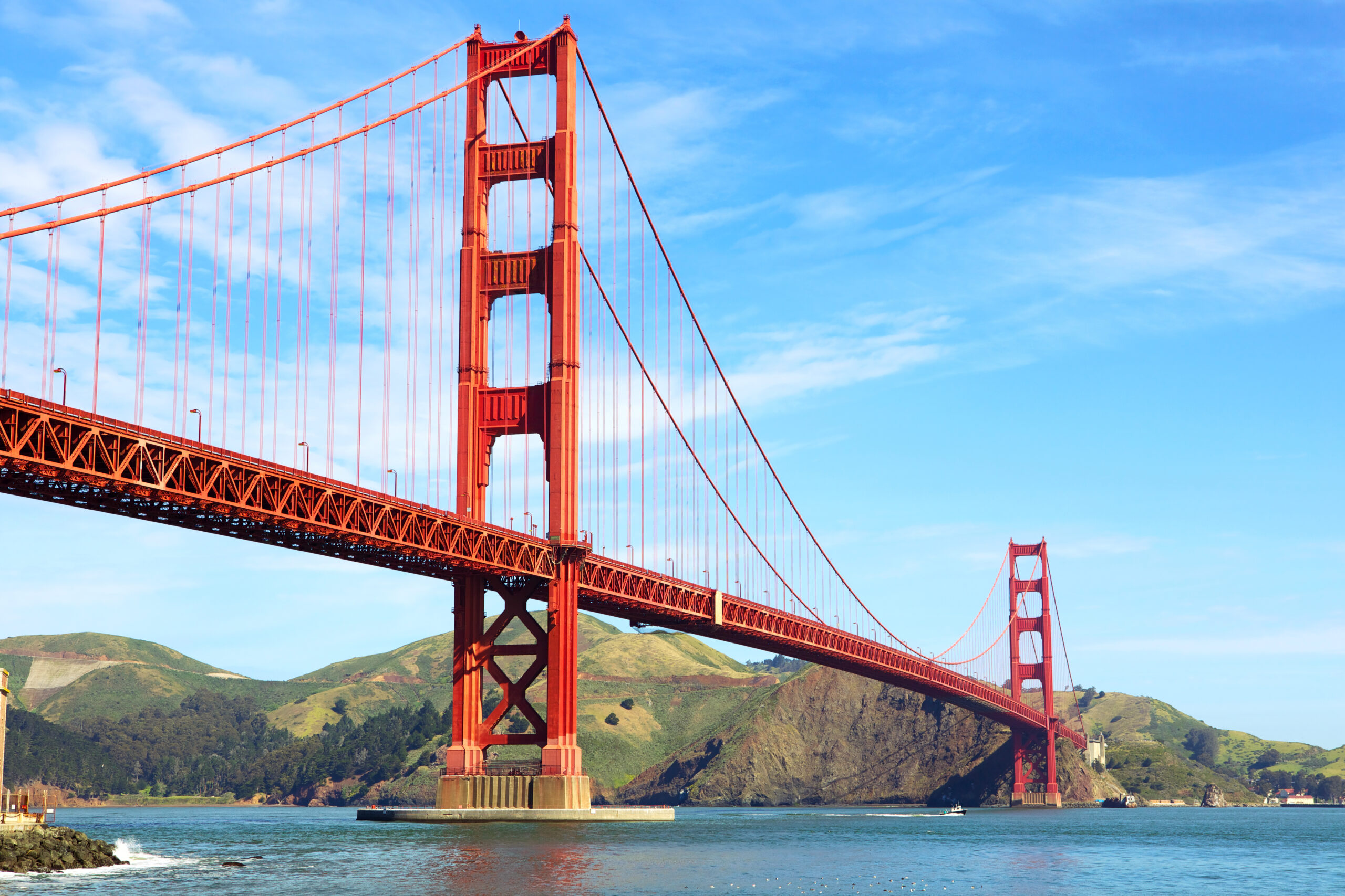 Photo of the Golden Gate Bridge with blue water underneath and gorgeous light blue sky