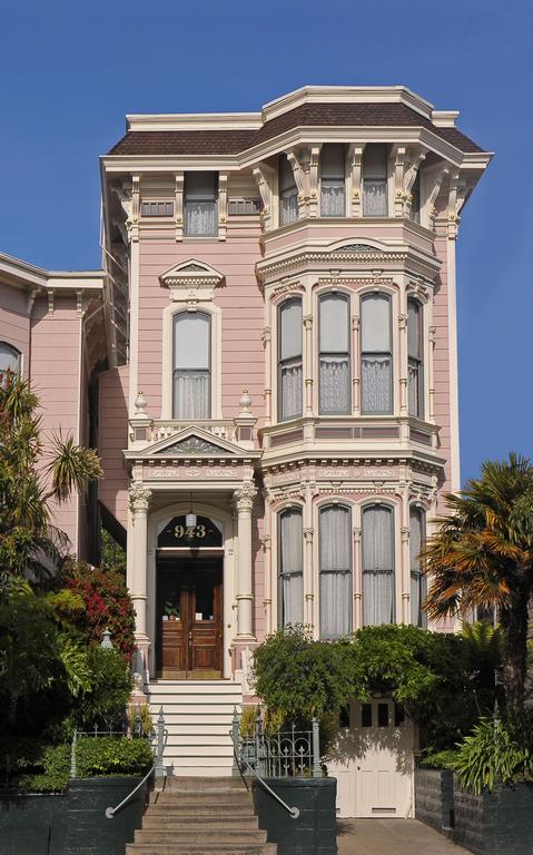 Photo of the front of the Inn San Francisco in the Mission District. One of the best places to stay in San Francisco. A Victorian style building with pale pink paint and a wooden front door is featured. 