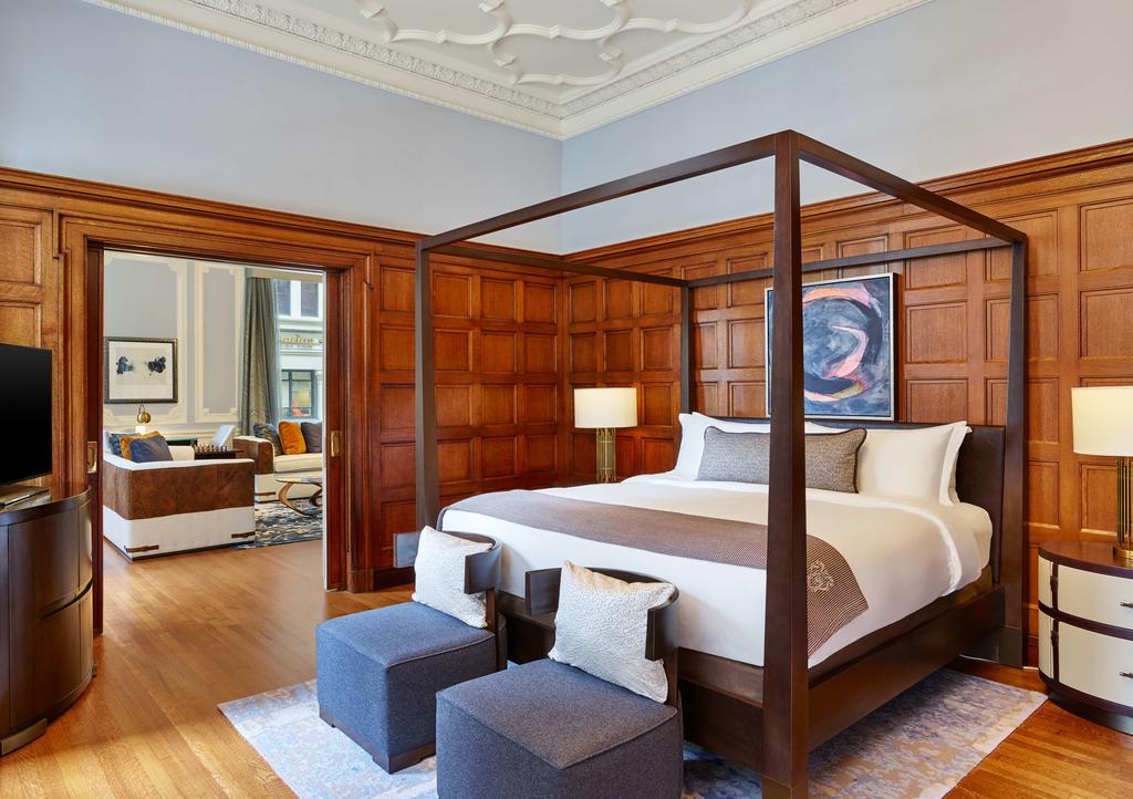 Photo of guest room at Palace Hotel in San Francisco. Featuring a very large guest room with many architectural accents. There is an open door leading to the suite's living room. 