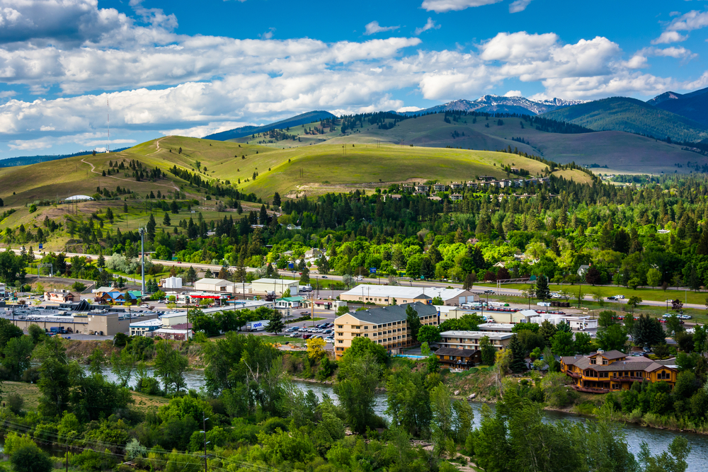 Missoula, Montana with a river, green trees, and a small town nestled among mountains