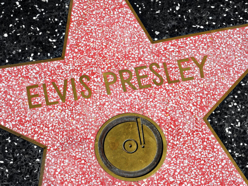 A close up of Elvis' Hollywood Star of Fame, a red star on black tile with his name spelled out across it.. 