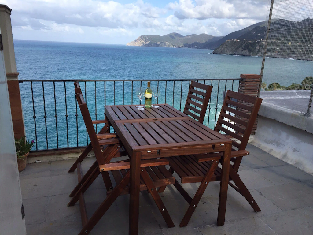 brown chairs in a VRBO in Manarola Italy with a sea view outside