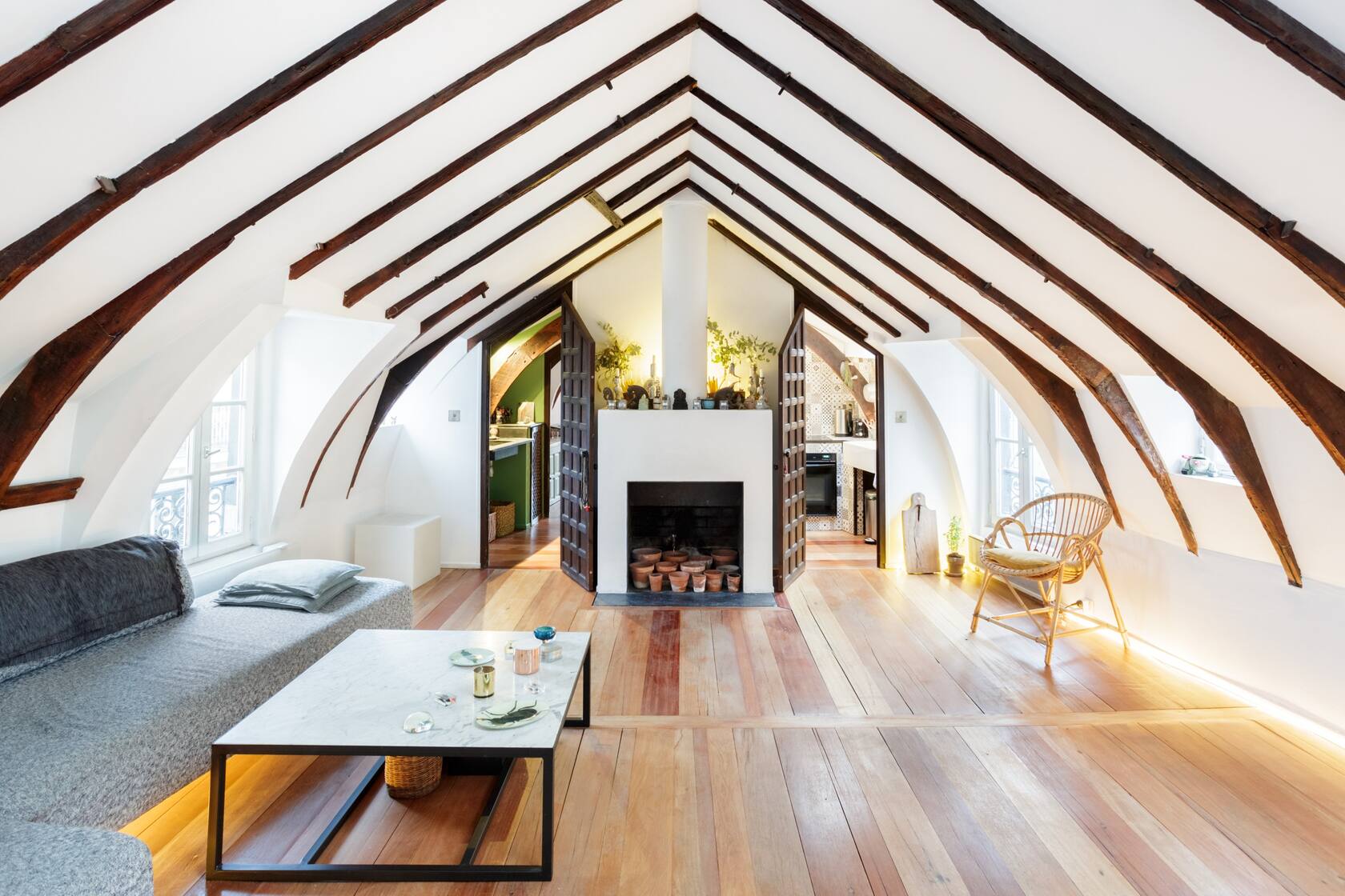 Photo of an Airbnb in Paris that is a historic loft featuring the living room with cathedral ceilings. 