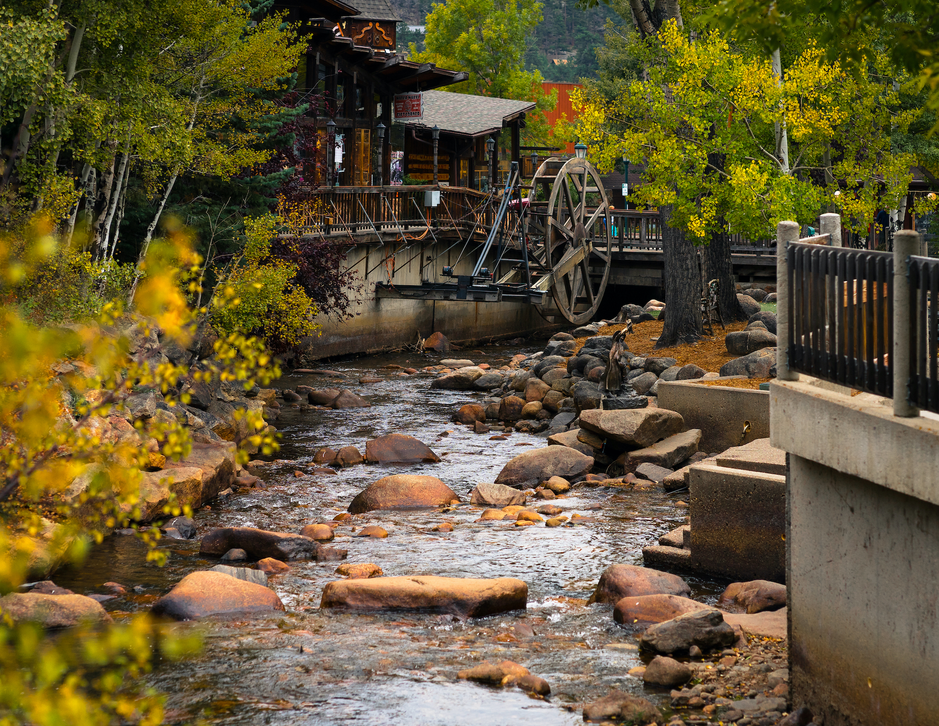 wooden homes of Estes Park along rocky stream