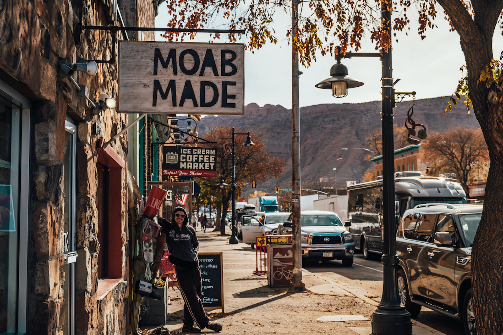 man standing in front of shop called Moab Made small towns in America