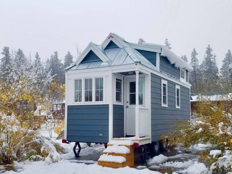 A tiny blue house in snowy surroundings 