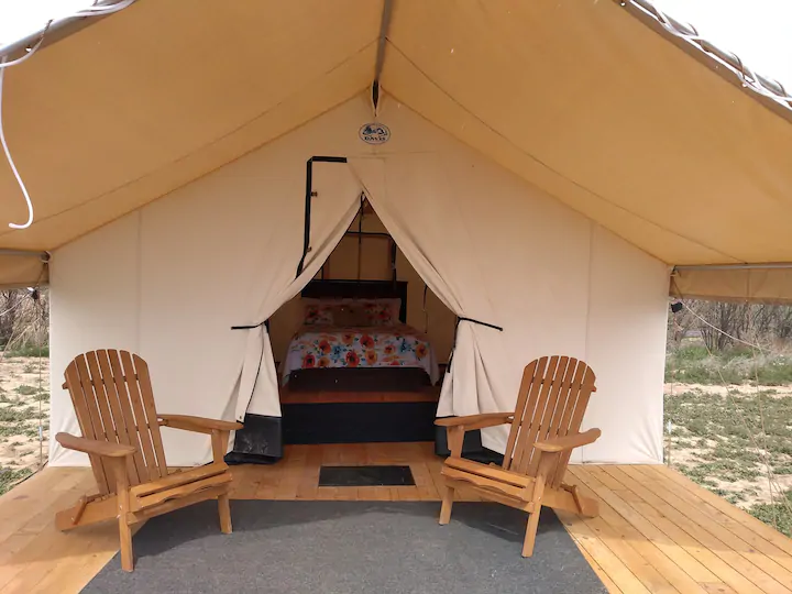 A glamping tent with two chairs outside