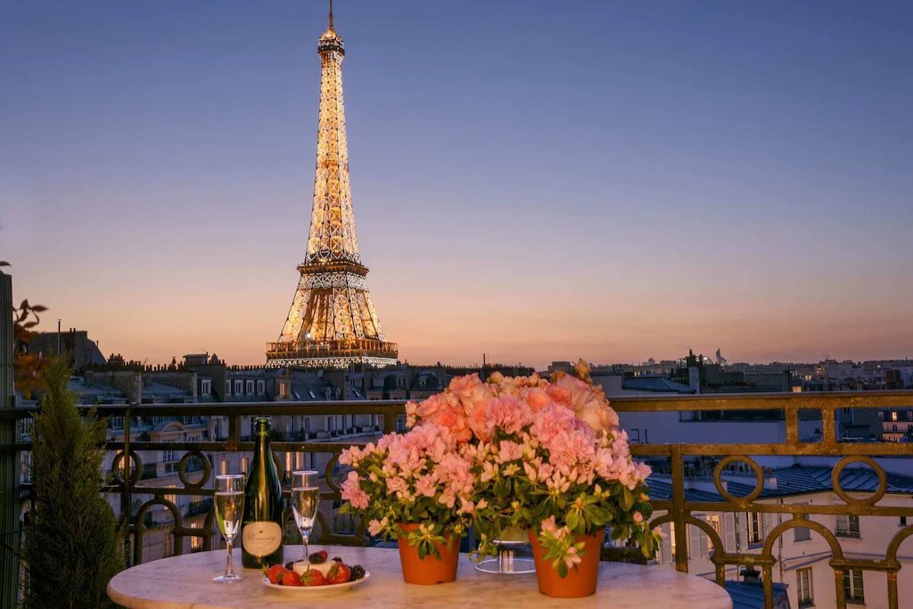 beautiful sunset view of the eiffel tower lit up from the balcony of this vacation rental
