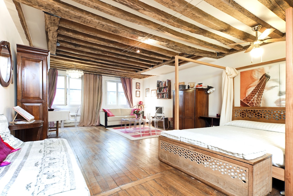 view of the exposed beams and wood floors of this apartment in paris