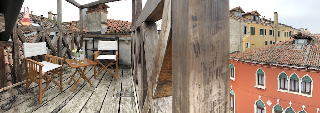 view of the charming wooden rooftop terrace and the city beyond 