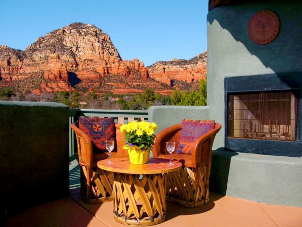 A patio with a set of colorful table and chairs with an amazing view of the Red Rocks in the background one of the best airbnbs in arizona 