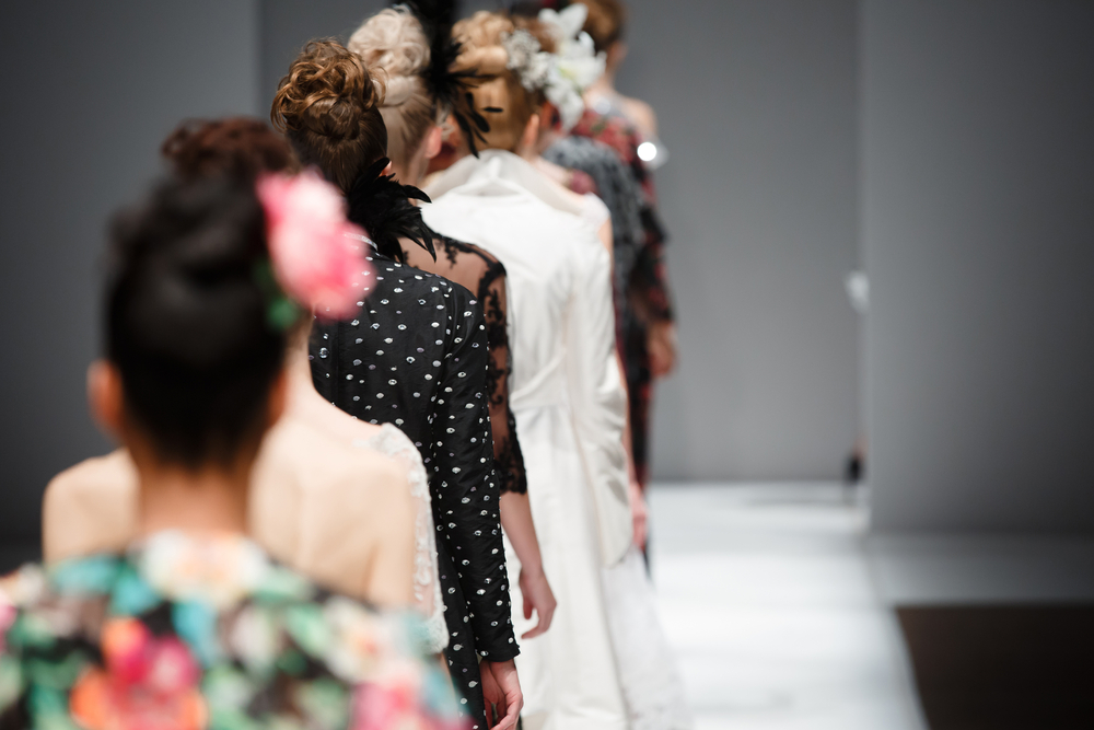Line of models walking away on a runway for New York Fashion Week.