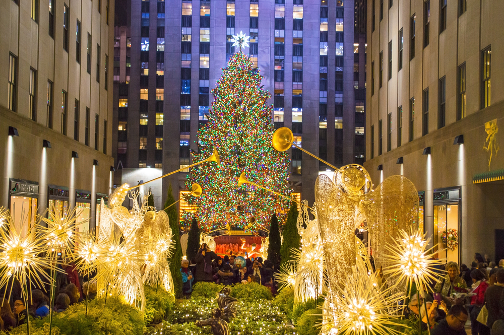 Christmas tree lit up and surrounded by angel statues New York in winter at night.