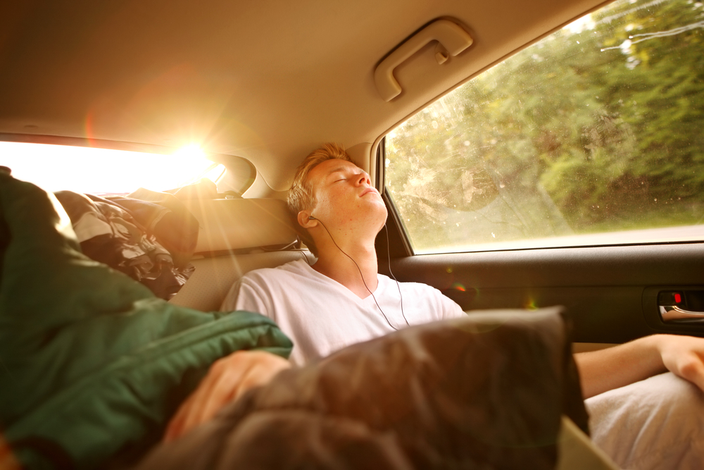 A passenger sleeps in the car