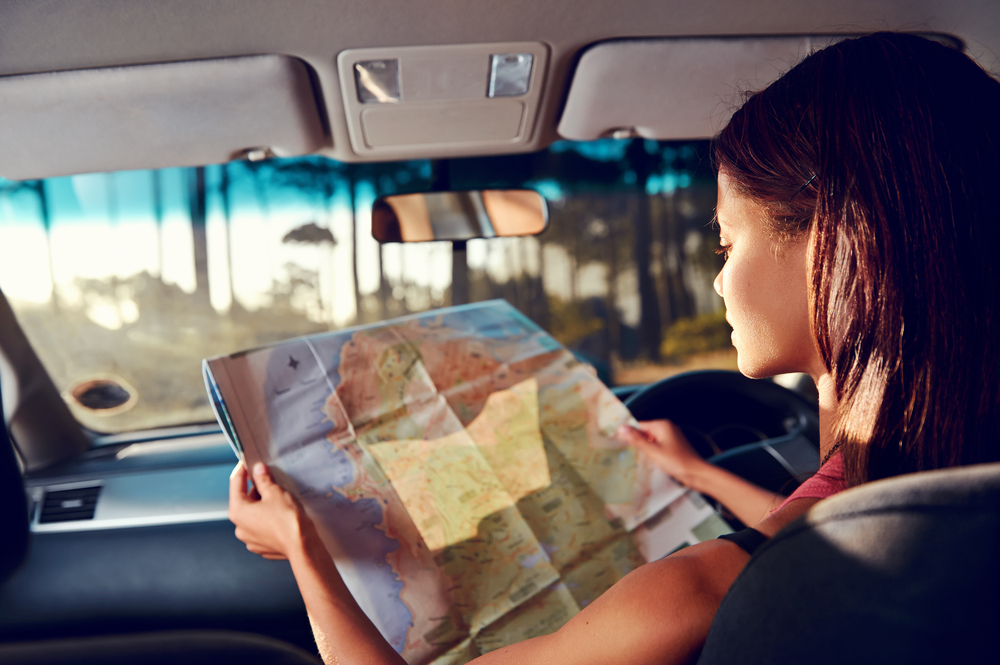 A girl looks at a map on a drive