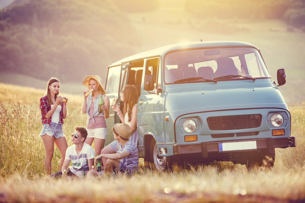 Friends gather outside a van