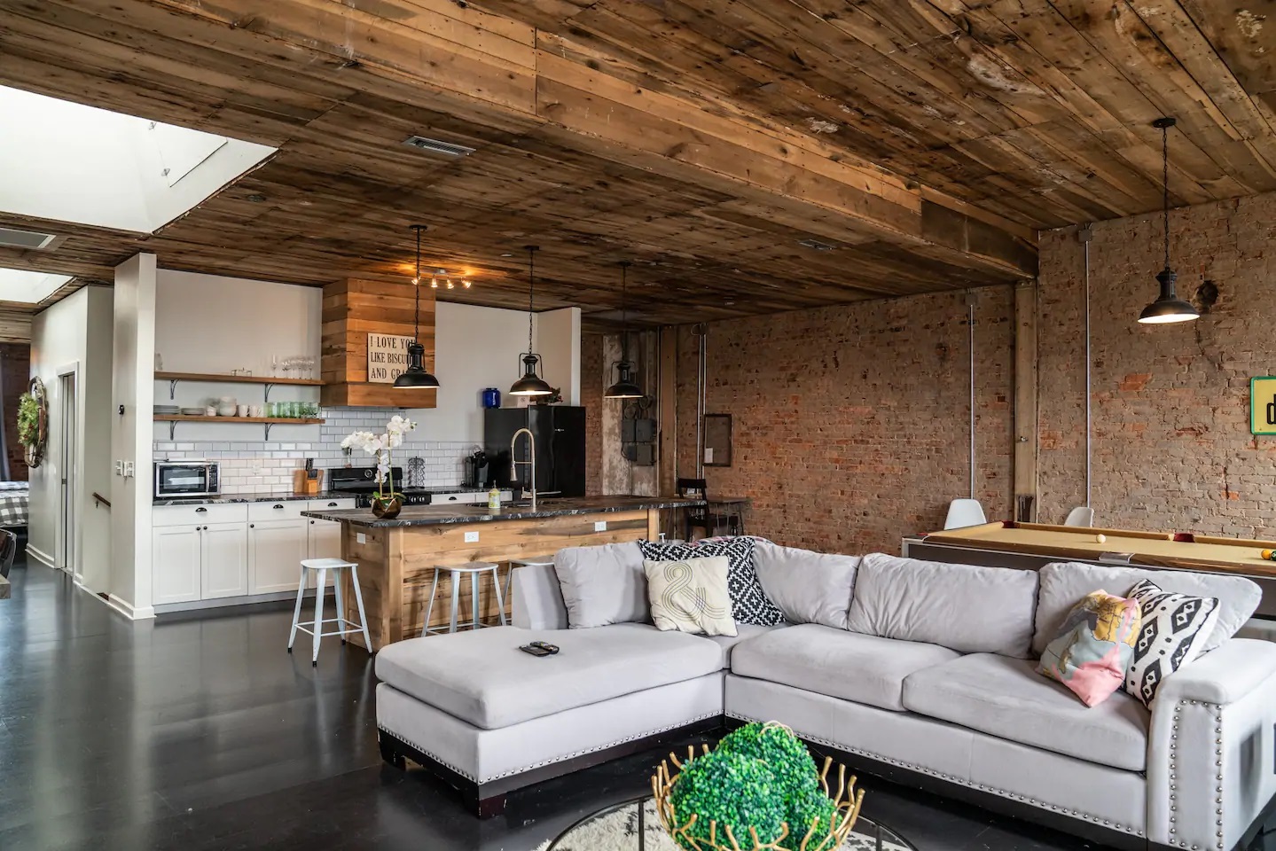 Photo of the living room and kitchen inside The Clover Penthouse Airbnb.