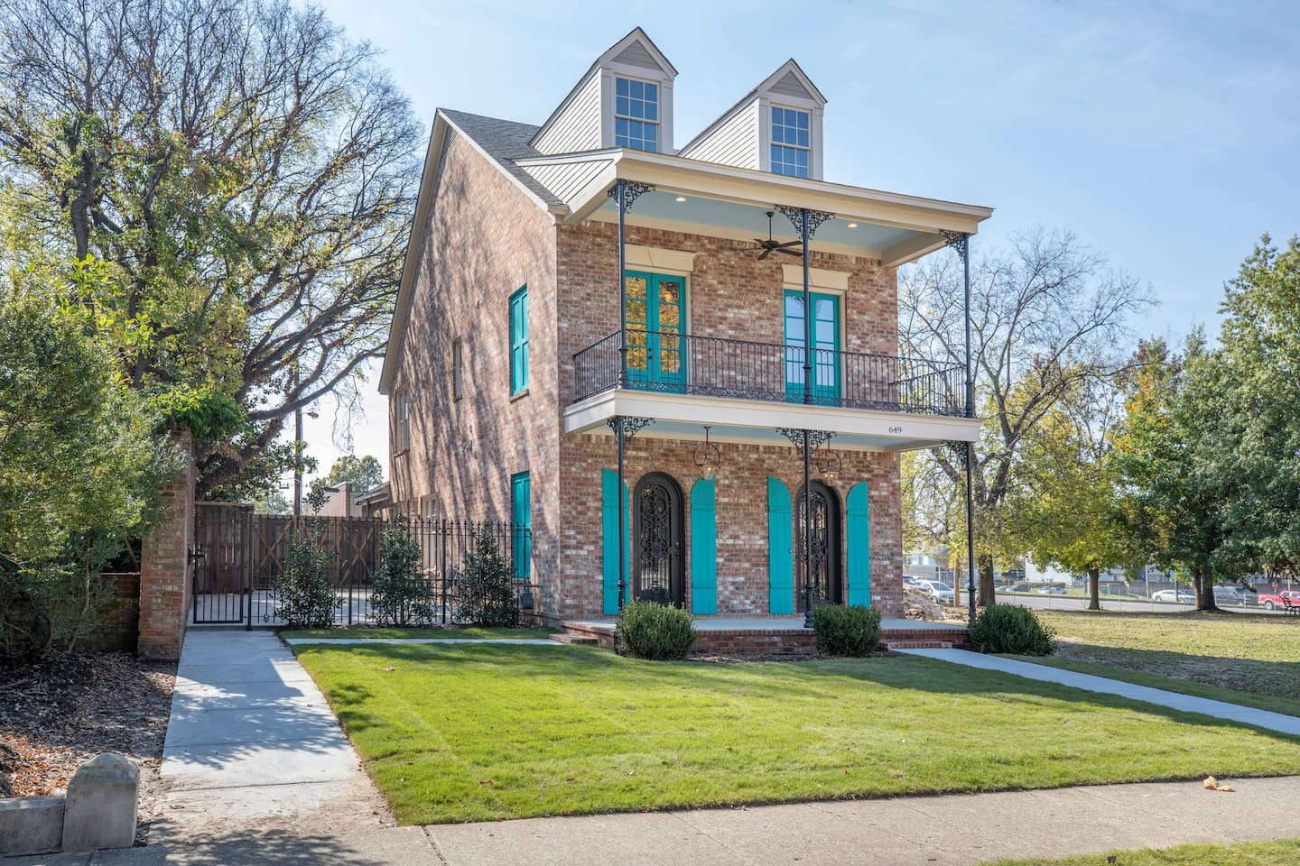 Photo of the exterior of The William Henry House with brick and aqua shutters.