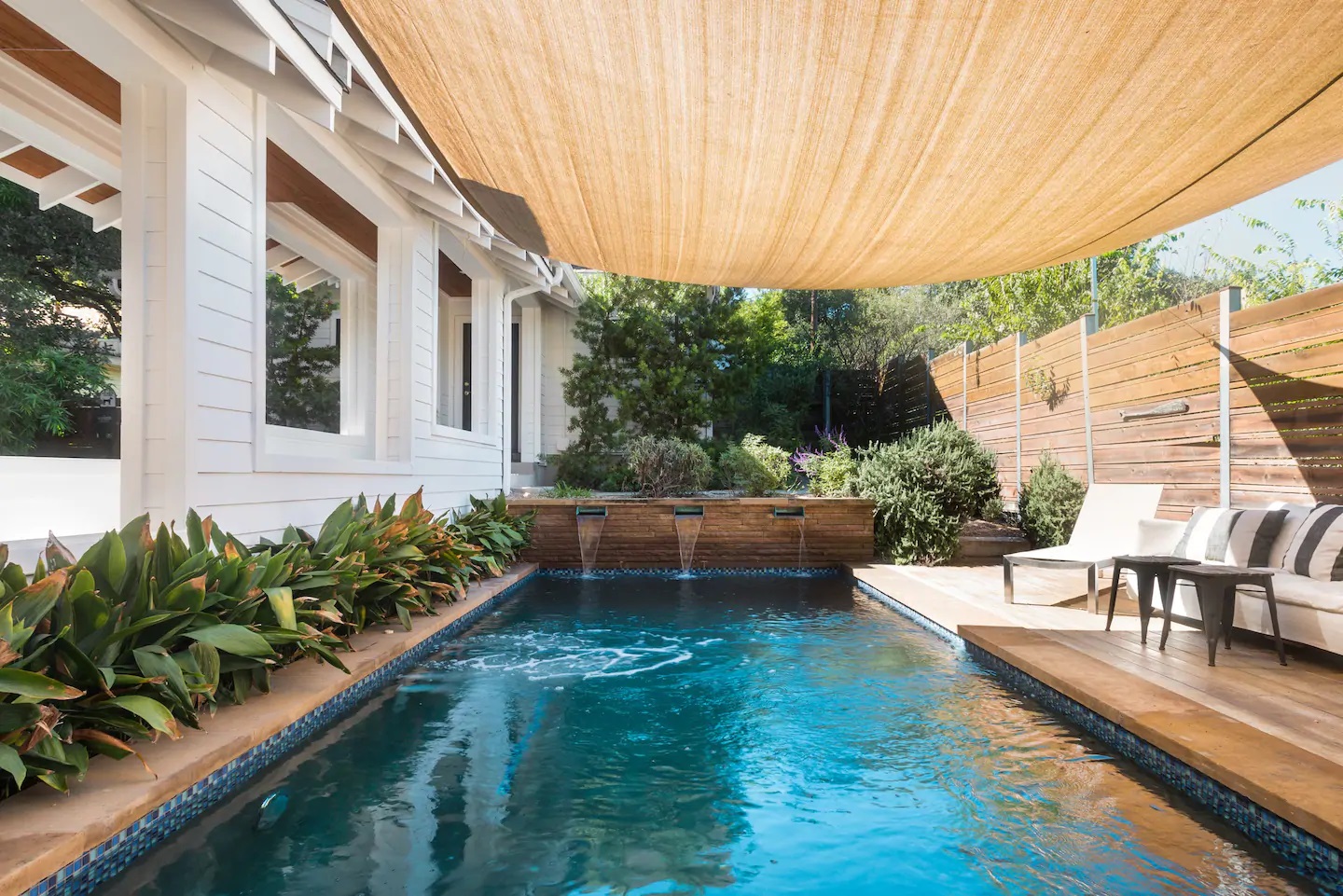 Photo of a sparkling pool and seating area at an Airbnb in Texas. 
