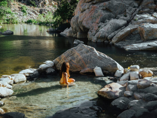 woman sitting in one of the best hot springs in california